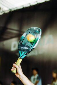 Action-packed padel racquet hitting ball indoors during intense match.