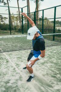 Man in sportswear energetically celebrating on a tennis court.