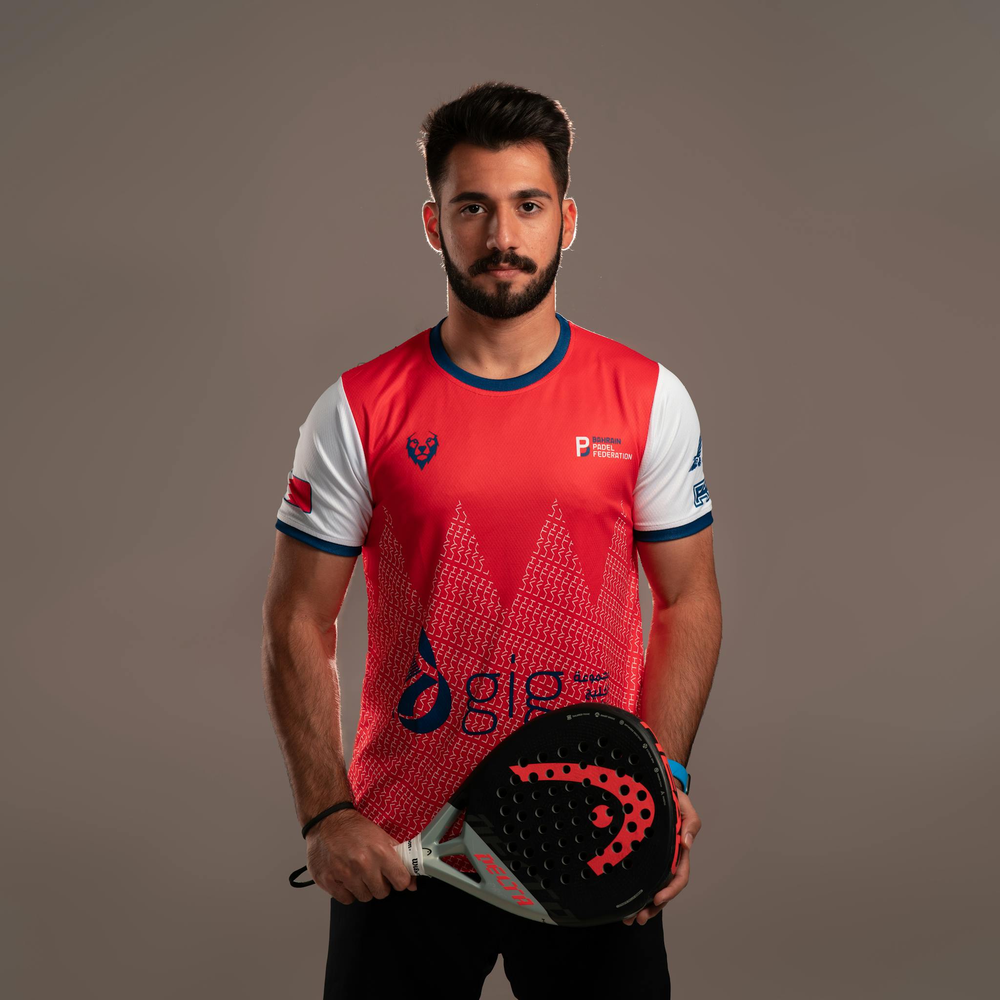 Portrait of a confident padel player in a studio setting with a neutral background.